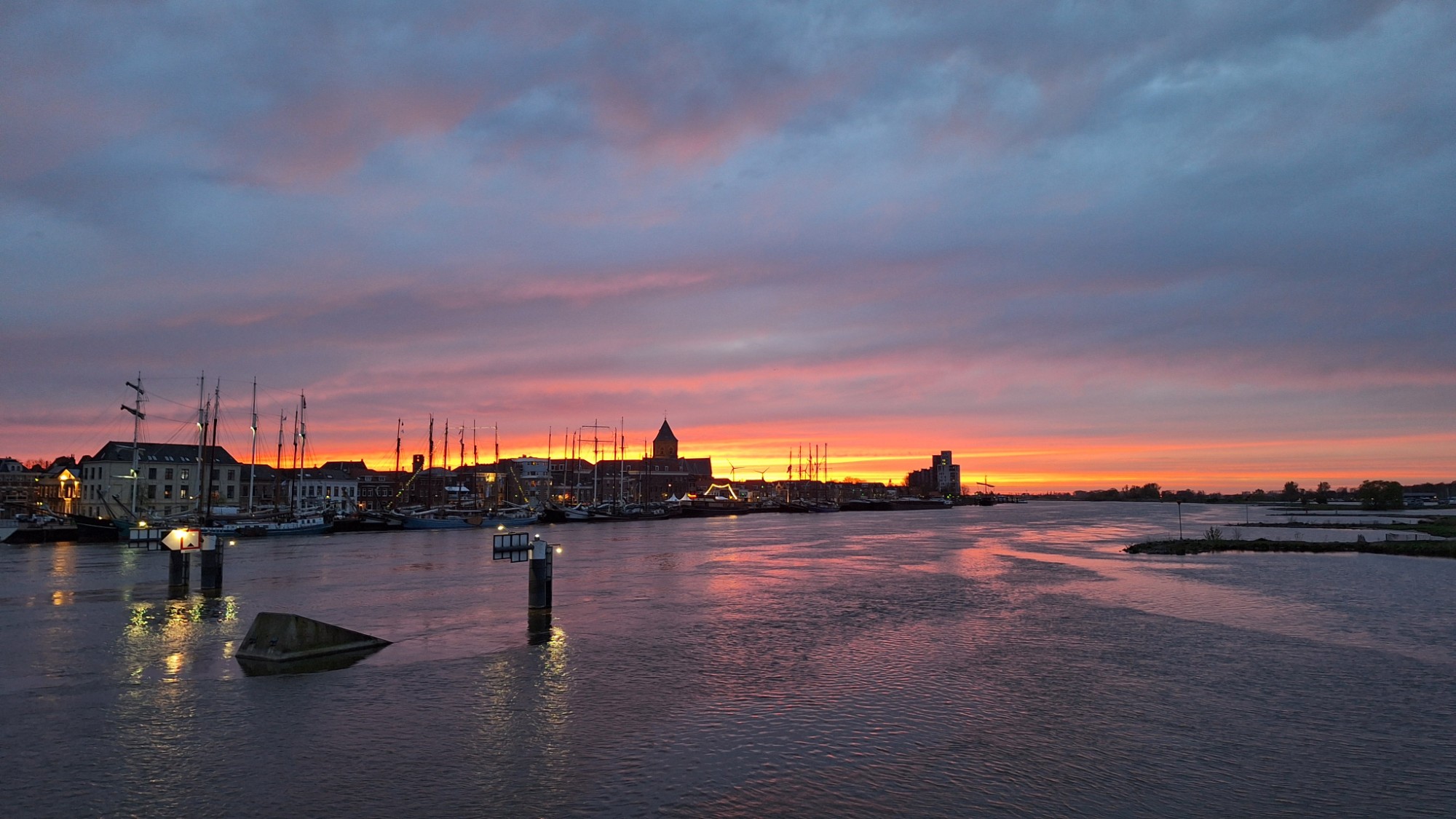 Spectaculaire zonsondergang boven de IJssel bij Kampen met de bruine vloot als silhouet